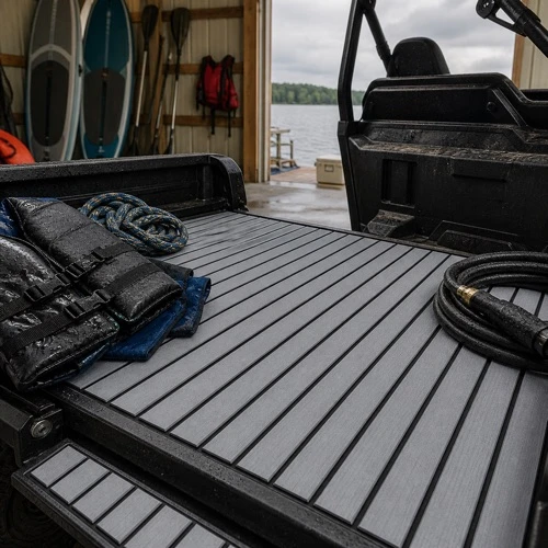 Gray striped mat surface on a wet utility tailgate with life jackets, rope, and a hose nearby.